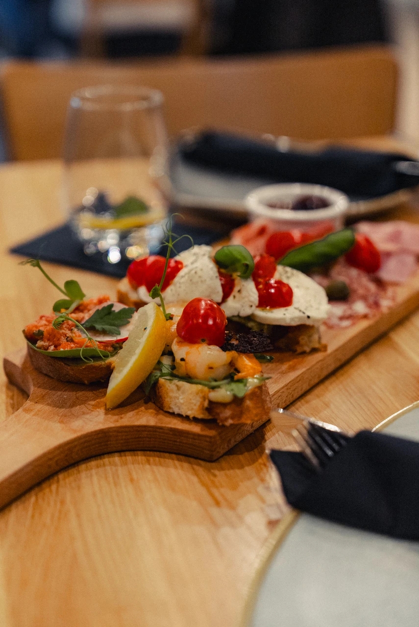 Deska przekąsek na drewnianej desce w Restauracji Krótka Karta w Koszalinie