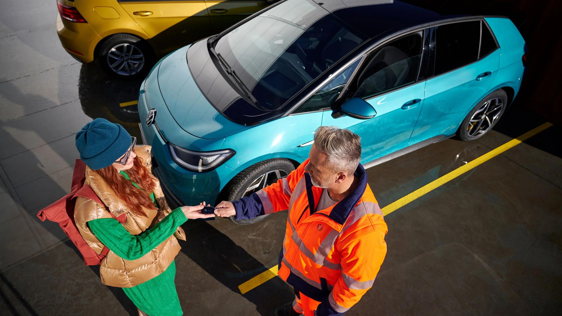 Pracownik warsztatu przekazuje kluczyki do samochodu klientce