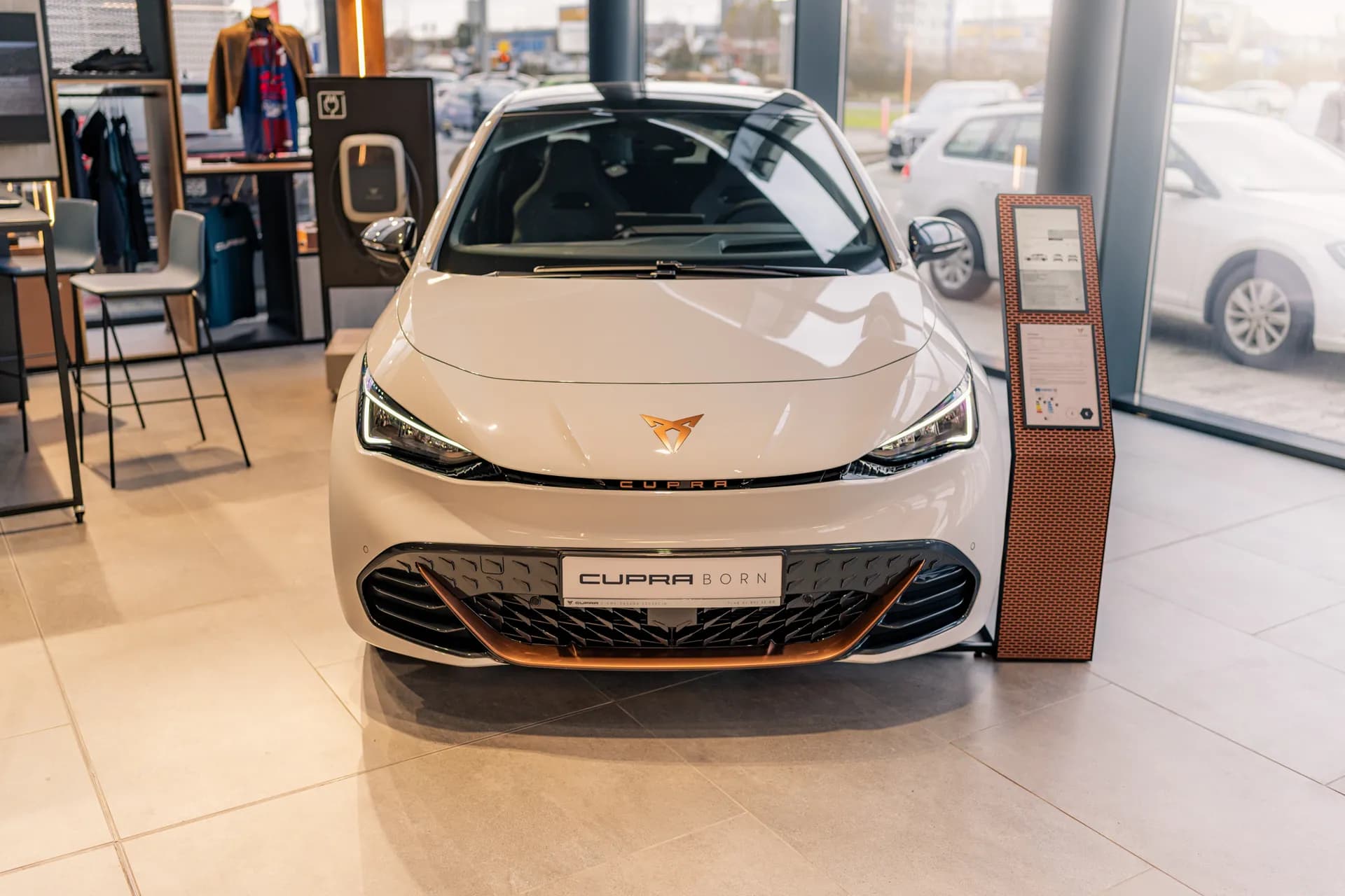 Biała Cupra Born przód w salonie – auto elektryczne Cupra