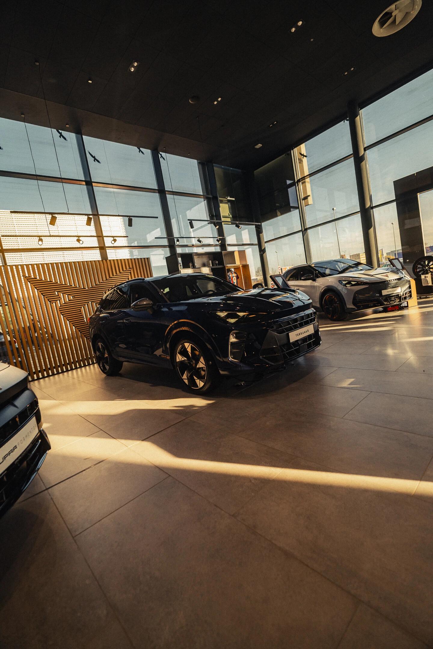 Nowa CUPRA Formentor w studio na tle figur geometrycznych w kolorze pomarańczowo-różowo-fioletowym