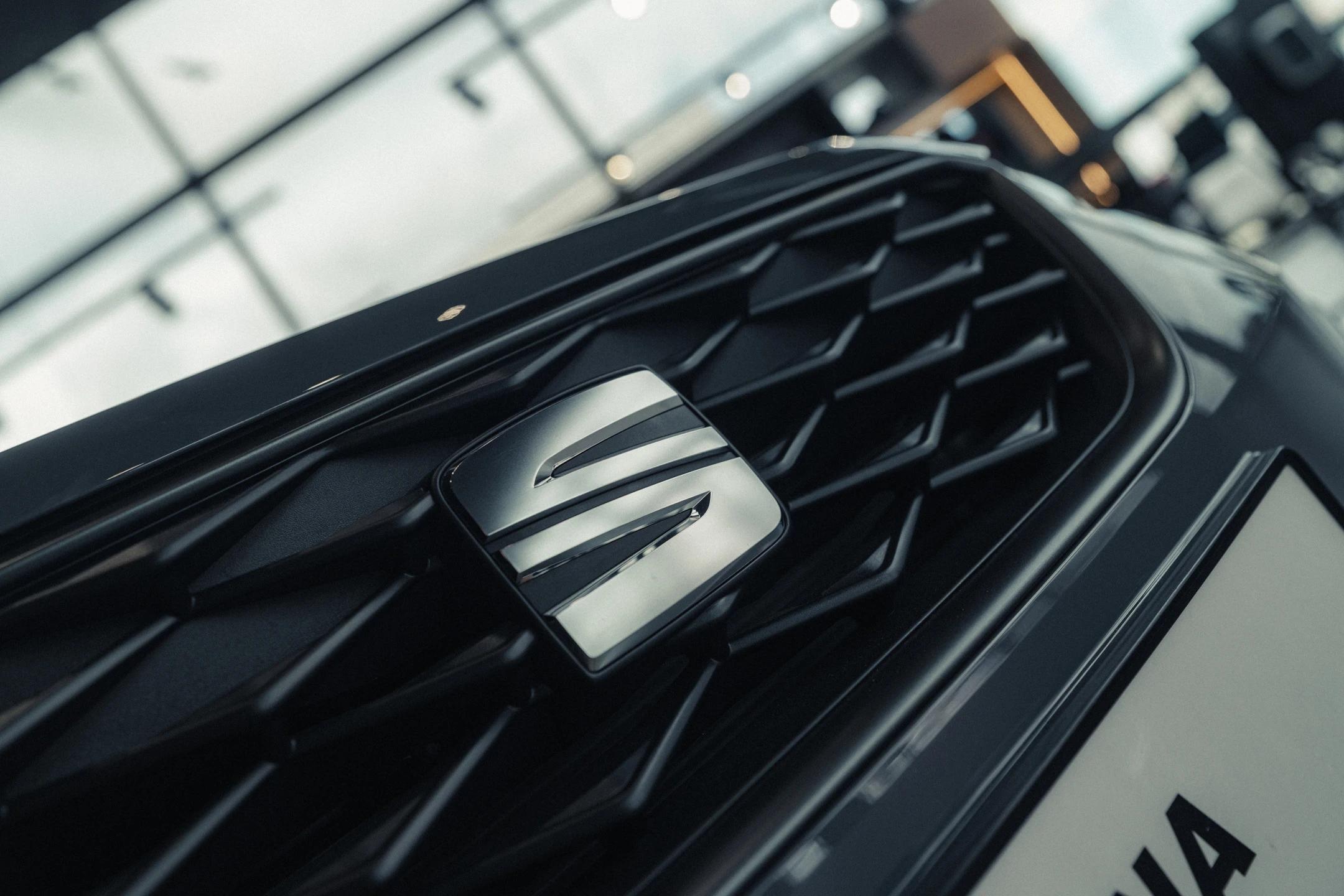 Zbliżenie na znaczek SEAT na masce Arony