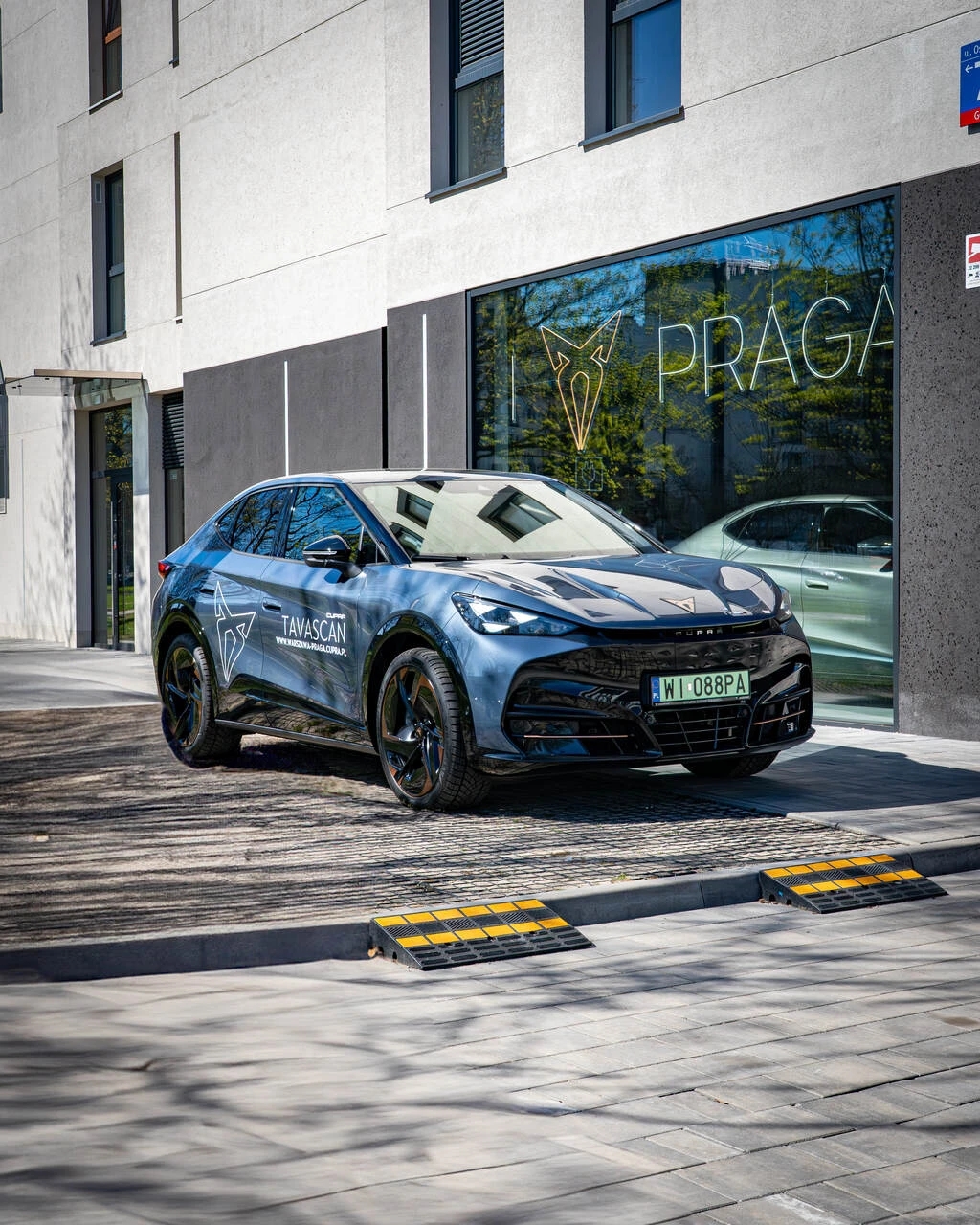 Nowa elektryczna CUPRA Tavascan pod napisem led na tle salonu na warszawskiej Pradze