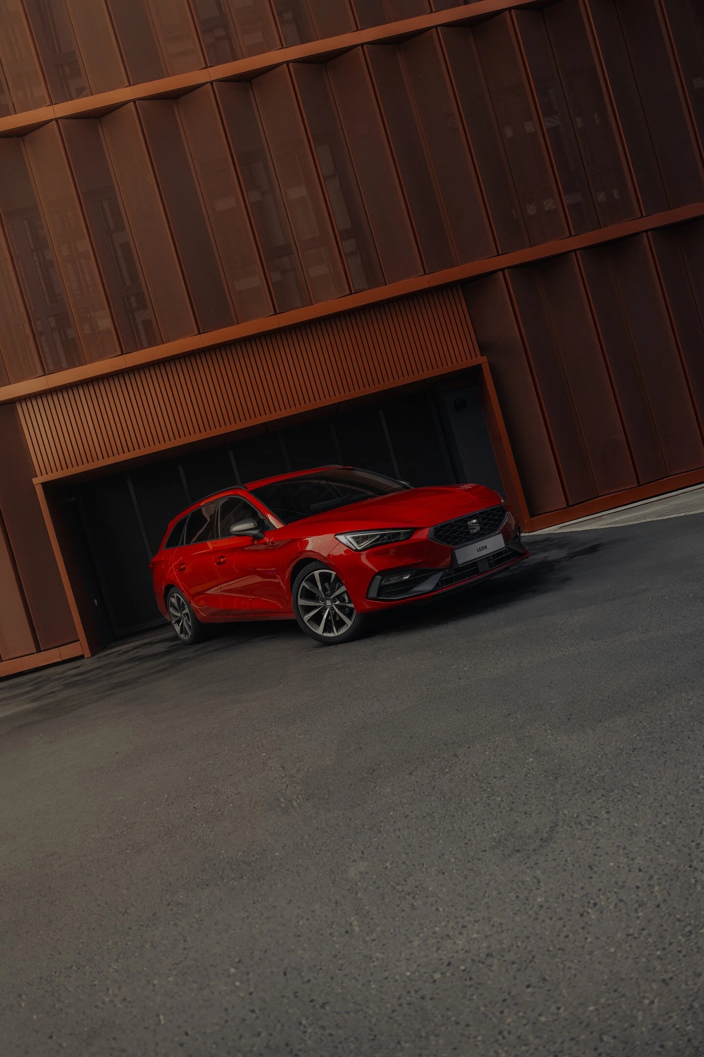 Czerwony SEAT Leon Sportstourer w zabudowie miejskiej