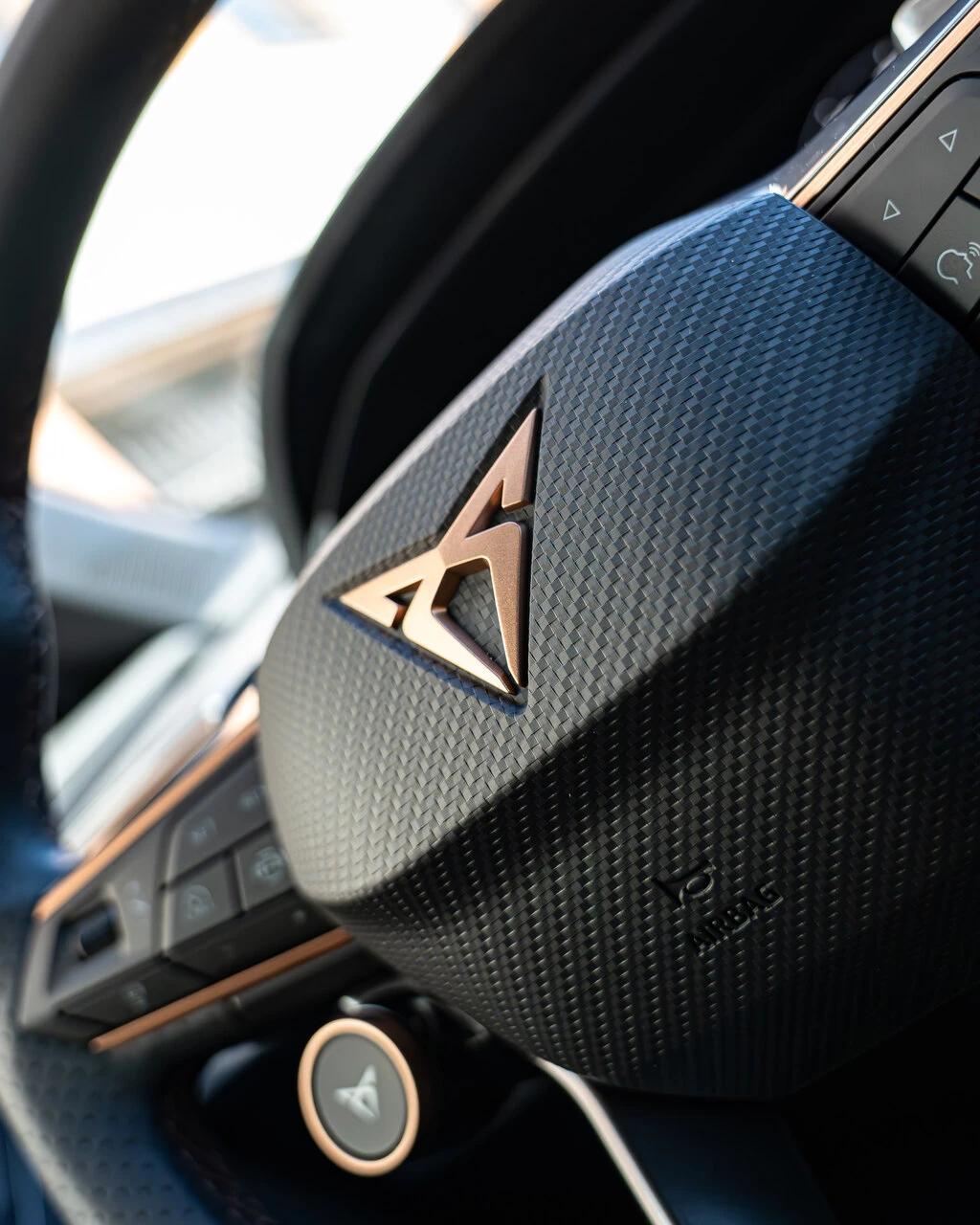 Zbliżenie na kierownicę z miedzianym logo CUPRY