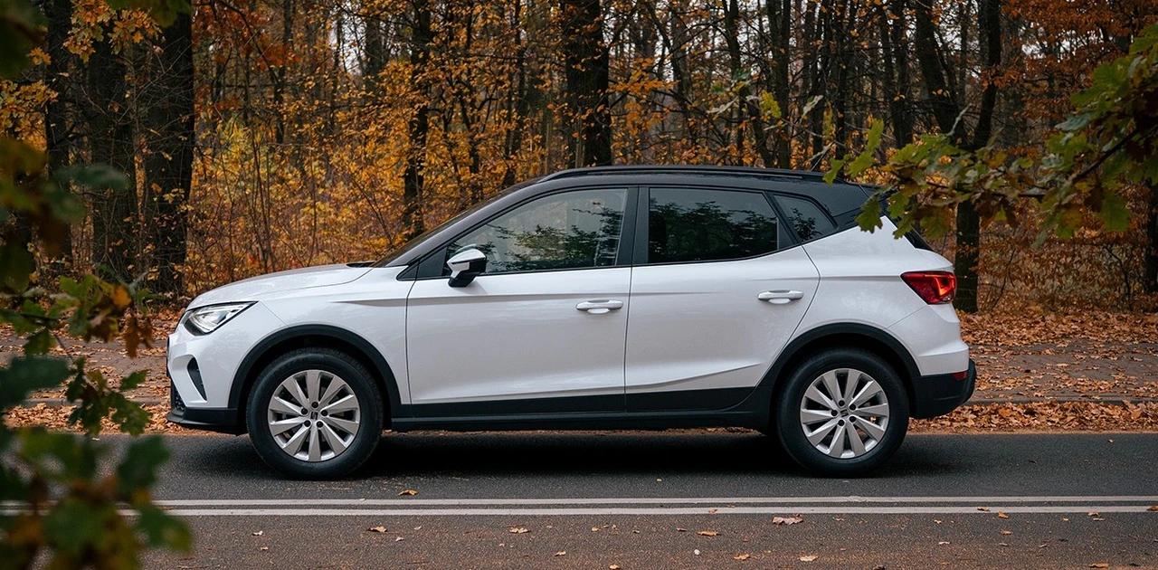 SEAT Arona na leśnej drodze w otoczeniu jesiennego lasu