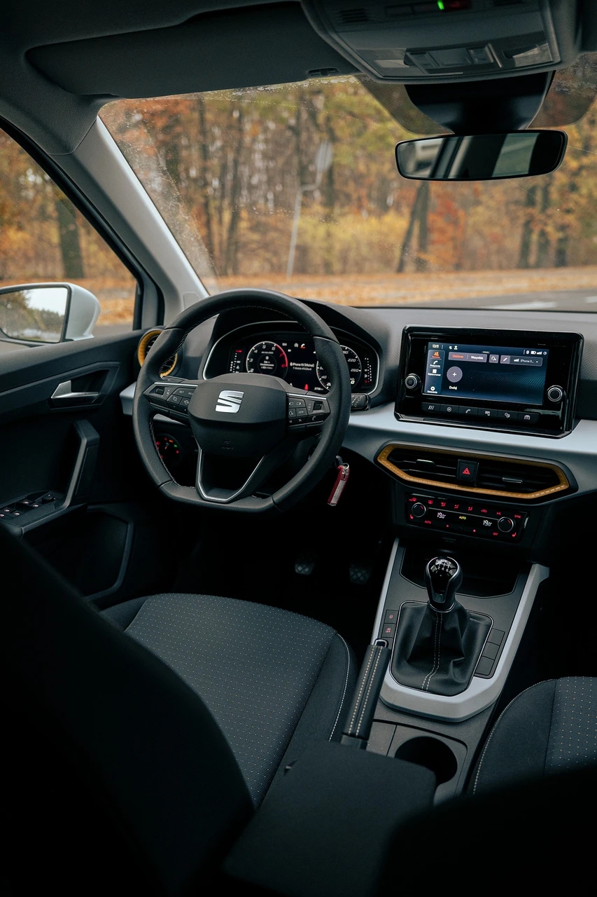 Miejsce kierowcy wewnątrz SEATA Arony w jesiennym lesie